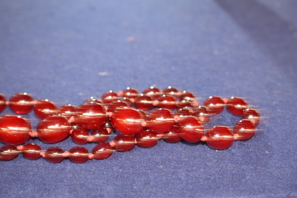 A single strand graduated simulated cherry amber bead necklace, gross weight 55 grams and assorted costume jewellery.